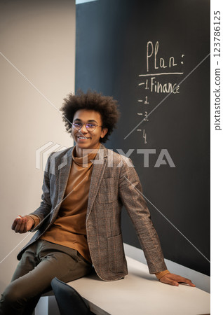 Young businessman looking confident and contented in the office Young businessman looking confident and contented in the office 123786125