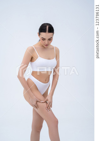 Young dark-haired woman checking her skin condition and feeling body positive Young dark-haired woman checking her skin condition and feeling body positive 123786131