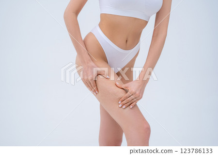Close up picture of a woman in white lingerie making cellulite self-test 123786133