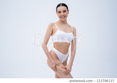 Young dark-haired woman checking her skin condition and feeling body positive Young dark-haired woman checking her skin condition and feeling body positive 123786137