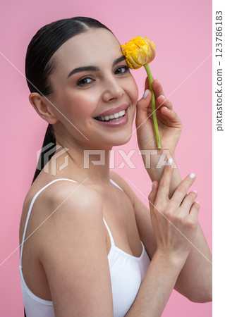Waist up picture of a young woman with yellow flower in hand 123786183