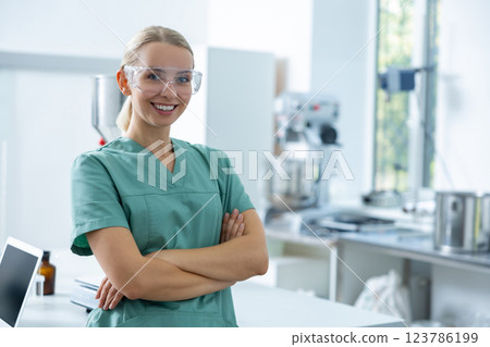 Woman wearing green uniform working in clinic laboratory posing in scientific workplace Woman wearing green uniform working in clinic laboratory posing in scientific workplace 123786199