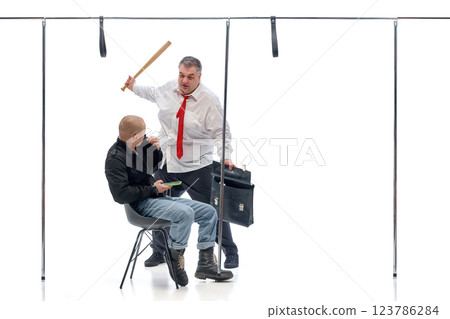 Businessman raising bat while younger man with phone reacts against white background. Concept of workplace stress 123786284