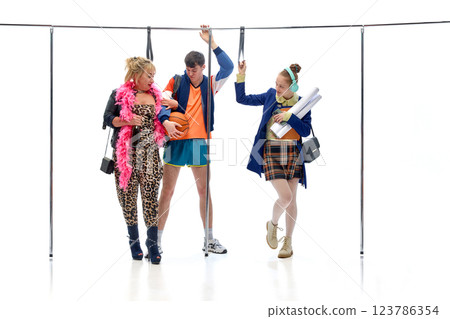Basketball player caught between two women, one glamorous, one academic, in subway setting against white studio background. 123786354