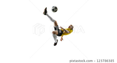Focused man, soccer player executing overhead kick, dynamically kicking ball in air and falling down against white background. 123786385