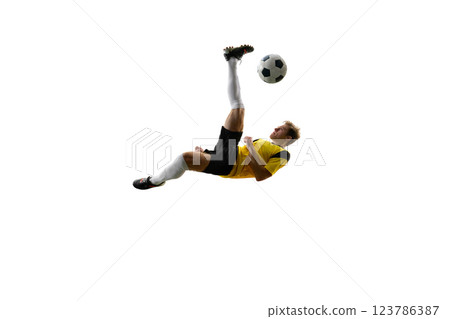 Young man, soccer player executing overhead kick, dynamically kicking ball in air and falling down against white background. Young man, soccer player executing overhead kick, dynamically kicking ball in air and falling down against white background. 123786387