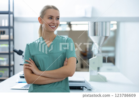 Successful female worker of scientific laboratory in uniform standing inside medical office Successful female worker of scientific laboratory in uniform standing inside medical office 123786609