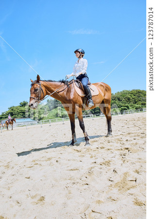 A woman practicing horse riding 123787014