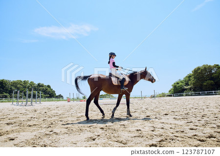 A woman practicing horse riding 123787107