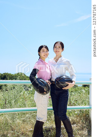 戴著頭盔站在騎馬俱樂部的女子 123787165