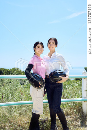戴著頭盔站在騎馬俱樂部的女子 123787166