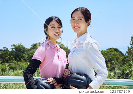 A woman standing with a helmet at a riding club A woman standing with a helmet at a riding club 123787169