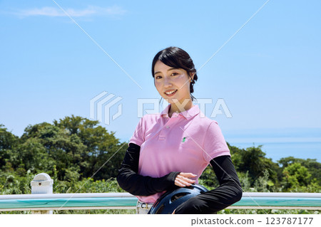 戴著頭盔站在騎馬俱樂部的女子 123787177