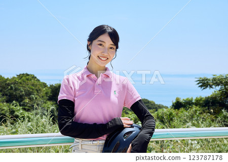 戴著頭盔站在騎馬俱樂部的女子 123787178