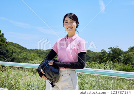 戴著頭盔站在騎馬俱樂部的女子 123787184