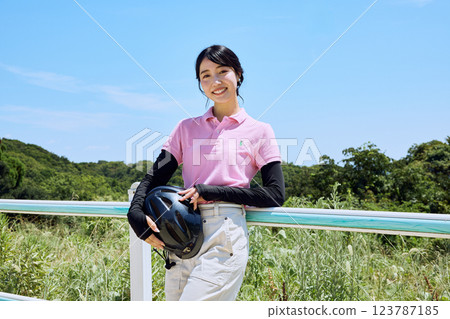 戴著頭盔站在騎馬俱樂部的女子 123787185