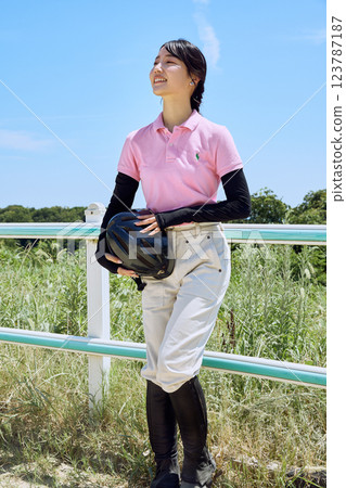 戴著頭盔站在騎馬俱樂部的女子 123787187