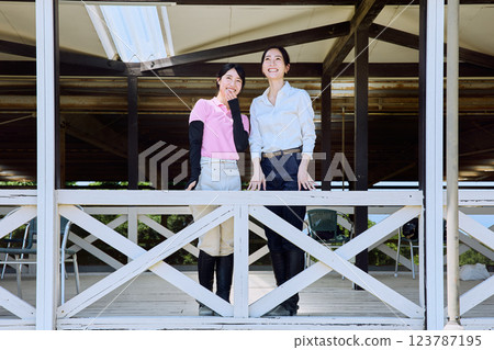 一位女士在騎馬俱樂部的露臺上看著賽馬場 123787195