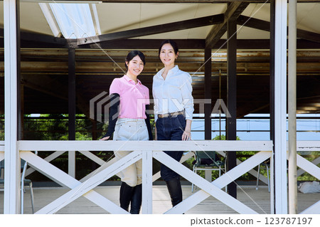 A woman looking at the riding arena from the terrace of a riding club 123787197