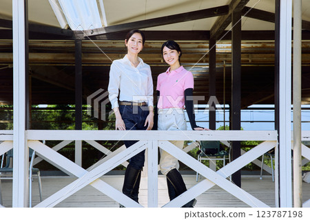 一位女士在騎馬俱樂部的露臺上看著賽馬場 123787198