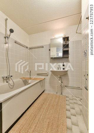 A contemporary bathroom featuring a bathtub, stylish sink, and modern tiles, creating a serene and functional space for relaxation. A contemporary bathroom featuring a bathtub, stylish sink, and modern tiles, creating a serene and functional space for relaxation. 123787953