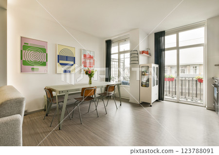 A stylish living room features a light wooden floor, contemporary furniture, and colorful wall art, creating an inviting and chic atmosphere. A stylish living room features a light wooden floor, contemporary furniture, and colorful wall art, creating an inviting and chic atmosphere. 123788091