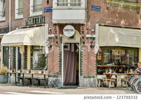 A picturesque Spaghetteria showcasing inviting outdoor seating. Modern architecture meets classic aesthetics, enhancing the urban dining experience. A picturesque Spaghetteria showcasing inviting outdoor seating. Modern architecture meets classic aesthetics, enhancing the urban dining experience. 123788332