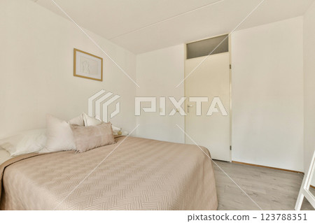 A serene and minimalistic bedroom featuring a soft color palette, simple decor, and natural light. The design emphasizes comfort and tranquility in a modern space. A serene and minimalistic bedroom featuring a soft color palette, simple decor, and natural light. The design emphasizes comfort and tranquility in a modern space. 123788351