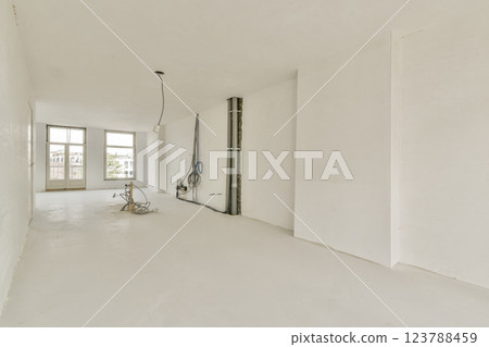 An expansive, bare interior featuring white walls and an unfinished look, showcasing potential for design and decoration. An expansive, bare interior featuring white walls and an unfinished look, showcasing potential for design and decoration. 123788459