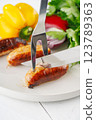 Grilled sausages with vegetables and herbs on a light background 123789363