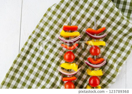 Vegetable kebab on skewers on a light wooden background 123789368