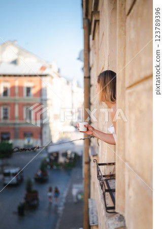 Young woman with glass of red wine on the balcony in the city Young woman with glass of red wine on the balcony in the city 123789396
