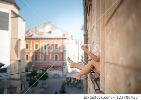 Young woman drinking coffee on the balcony of a building in the city Young woman drinking coffee on the balcony of a building in the city 123789418