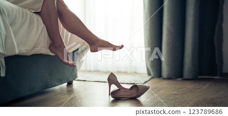 Womans feet in white bathrobe lying on sofa and relaxing at the room 123789686