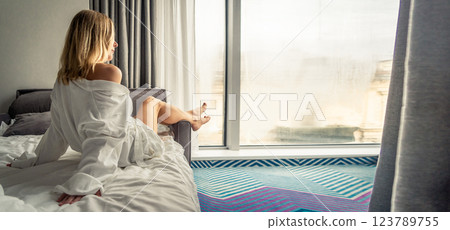 Woman in white bathrobe lying on sofa and relaxing at home. 123789755