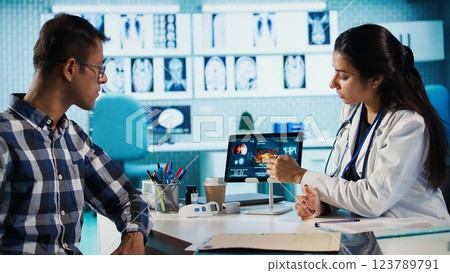 Medical expert and patient meeting at a check up appointment to discuss lab test results and potential treatment for recovery. Healthcare industry with medical insurance services. Camera B. 123789791