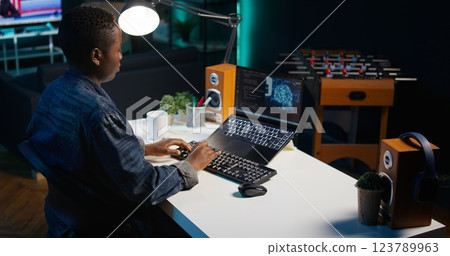 AI expert writes code on laptop in apartment office using Java programming languages. Artificial intelligence programmer remotely working on fixing database errors while working from home, camera B 123789963