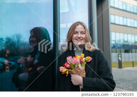 Happy International Women's Day Concept. Beautiful happy Caucasian woman smelling bunch of tulips with closed eyes Happy International Women's Day Concept. Beautiful happy Caucasian woman smelling bunch of tulips with closed eyes 123790193