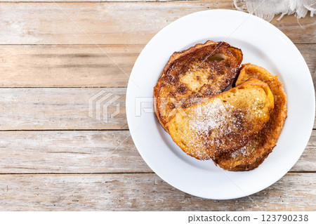 Traditional Spanish torrijas for Holy Week on wooden table. French Toast. Traditional Spanish torrijas for Holy Week on wooden table. French Toast. 123790238