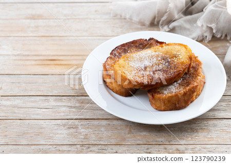 Traditional Spanish torrijas for Holy Week on wooden table. French Toast. Traditional Spanish torrijas for Holy Week on wooden table. French Toast. 123790239