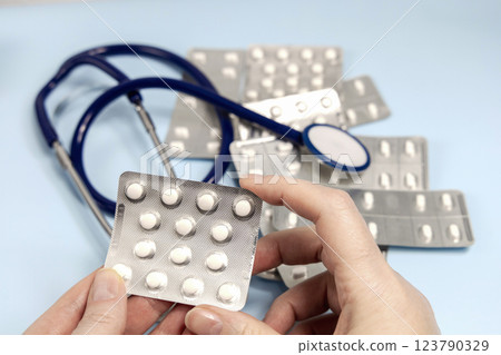 Female hands holding pills in blister. Prescription medication 123790329