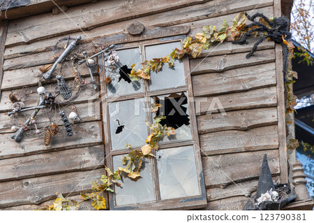 Old wooden house with broken glass in the window. Halloween concept Old wooden house with broken glass in the window. Halloween concept 123790381