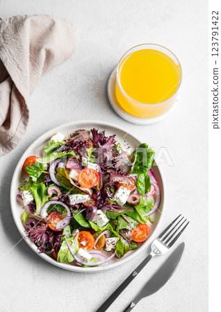 Vegetable salad (Greek salad) with tomatoes, cheese, lettuce, olives and onion in a plate Vegetable salad (Greek salad) with tomatoes, cheese, lettuce, olives and onion in a plate 123791422