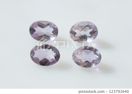Four Glittering Natural Oval-Cut Purple Amethyst Gemstones on White Background 123791640
