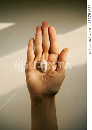 Open hand holding small seashell in sunlight 123791683