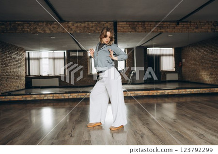 Dancer performs contemporary moves in spacious studio with wooden floors Dancer performs contemporary moves in spacious studio with wooden floors 123792299