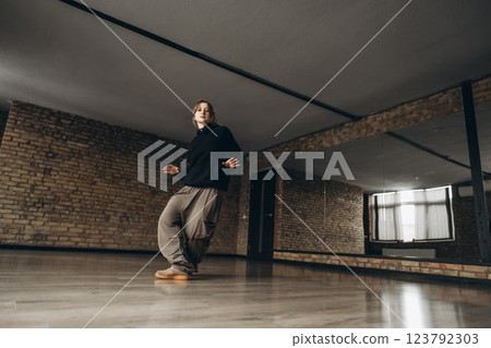 Dancing enthusiast practices in spacious studio with wooden floor 123792303