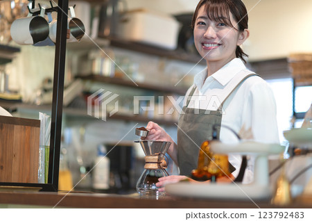 A cafe attendant preparing to make coffee 123792483
