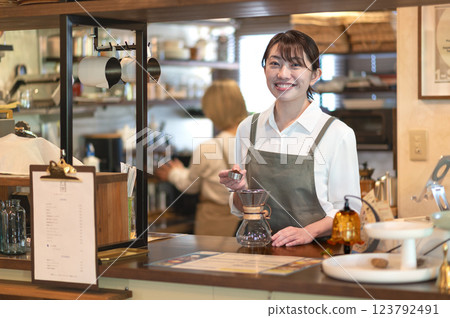 一名咖啡館服務員正在準備煮咖啡 一名咖啡館服務員正在準備煮咖啡 123792491