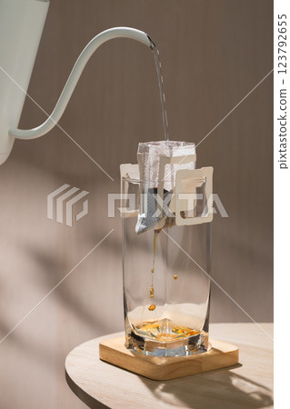 Hot water is being poured into a drip bag to brew coffee. Hot water is being poured into a drip bag to brew coffee. 123792655